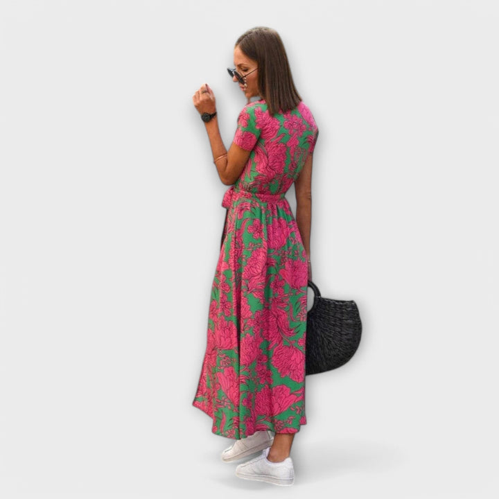 Back view of pink and green floral midi dress showing flowing pleated skirt