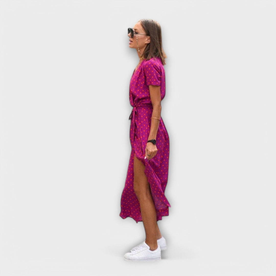 Side profile of magenta polka dot midi dress showing tie waist and split hem