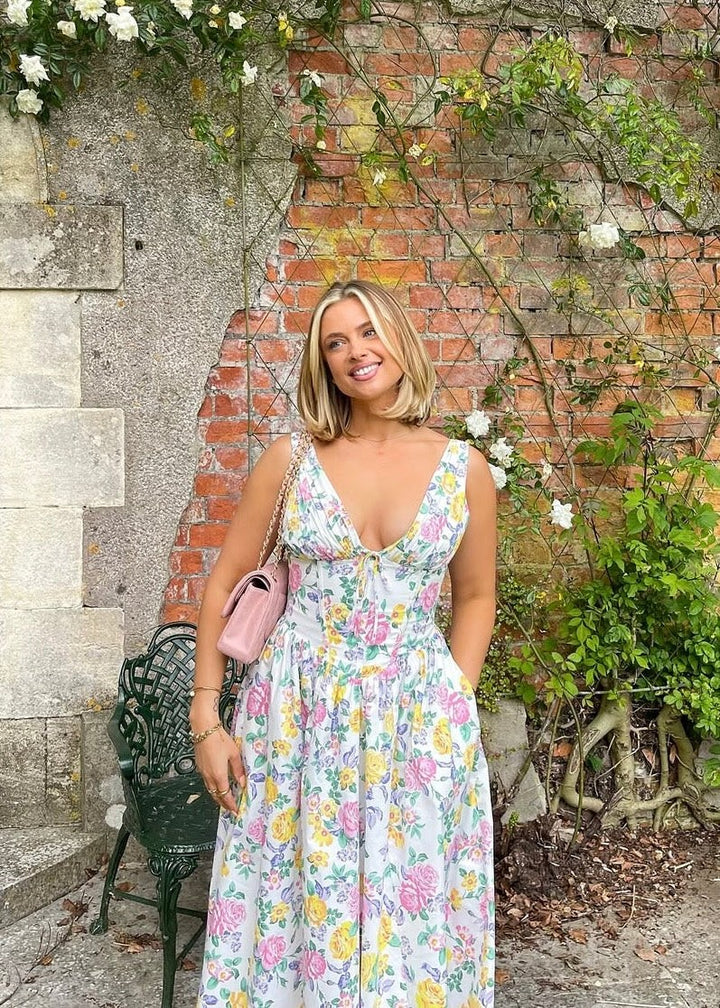 Woman wearing floral midi dress with plunge neckline in garden setting
