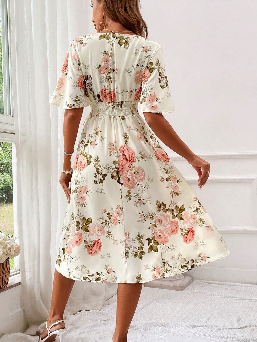 Rear view of cream floral midi dress showing flutter sleeves and shirred waistband