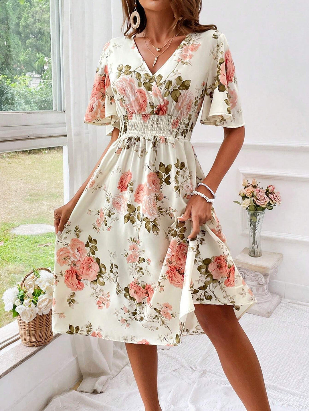 Cream floral V-neck midi dress paired with straw hat and flowing skirt