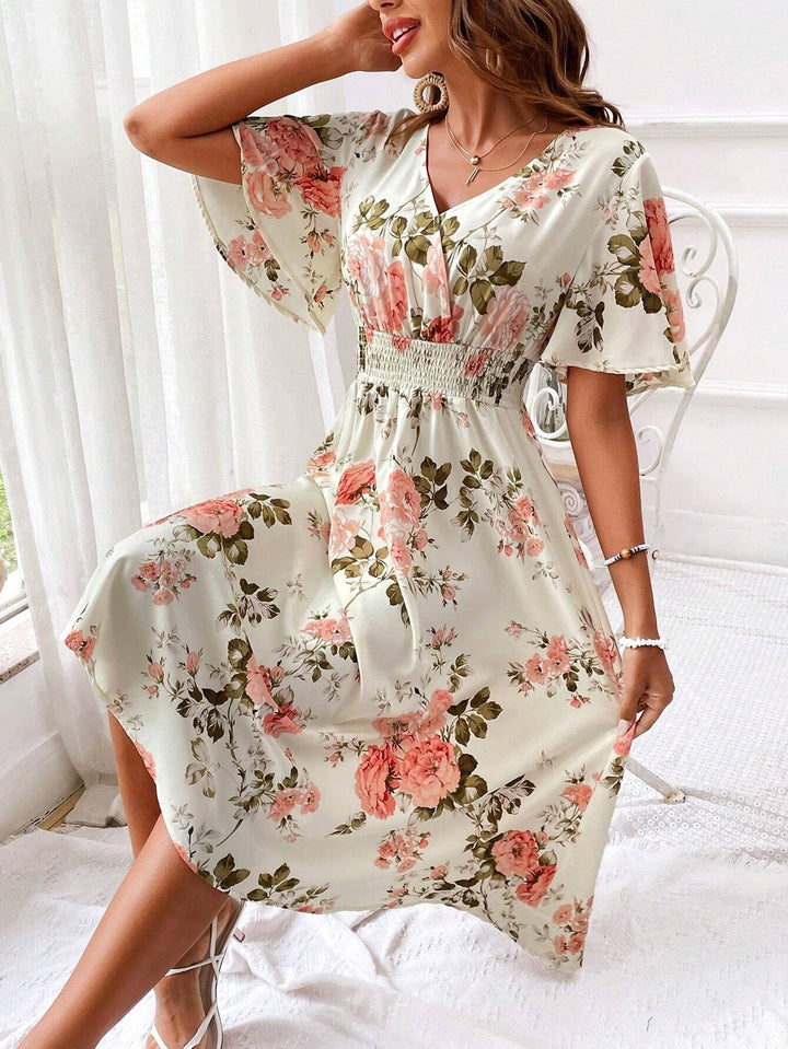 Cream floral midi dress with smocked waist, worn seated on a chair