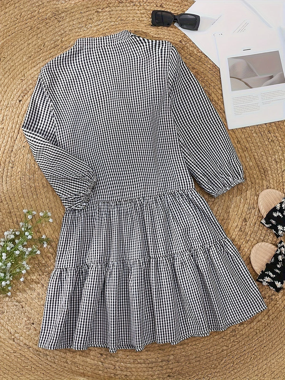 Black and white gingham shirt dress laid flat showing tiered ruffle hem