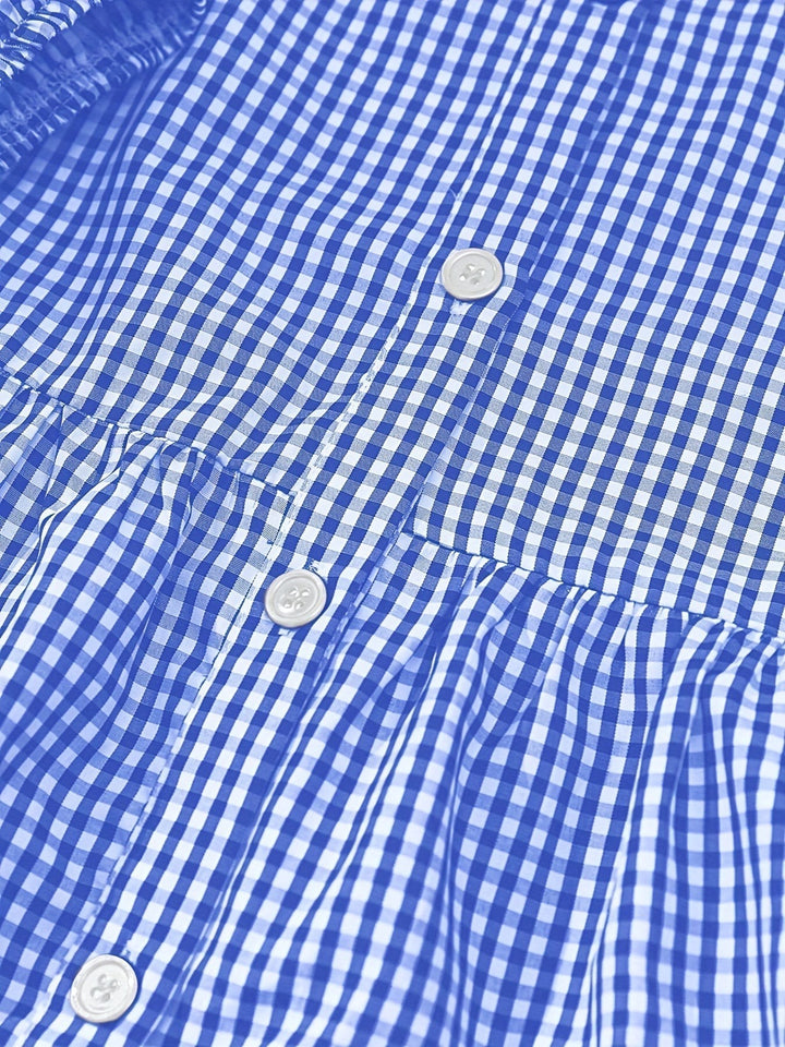 Close-up of blue gingham fabric with pearl buttons on tiered dress