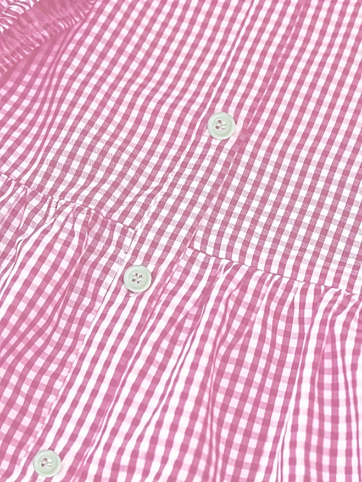Close-up of pink gingham fabric showing button fastenings and ruching