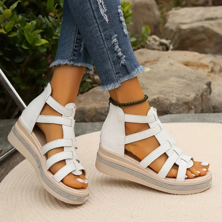 White gladiator sandals showing strappy cage upper and rear zip fastening
