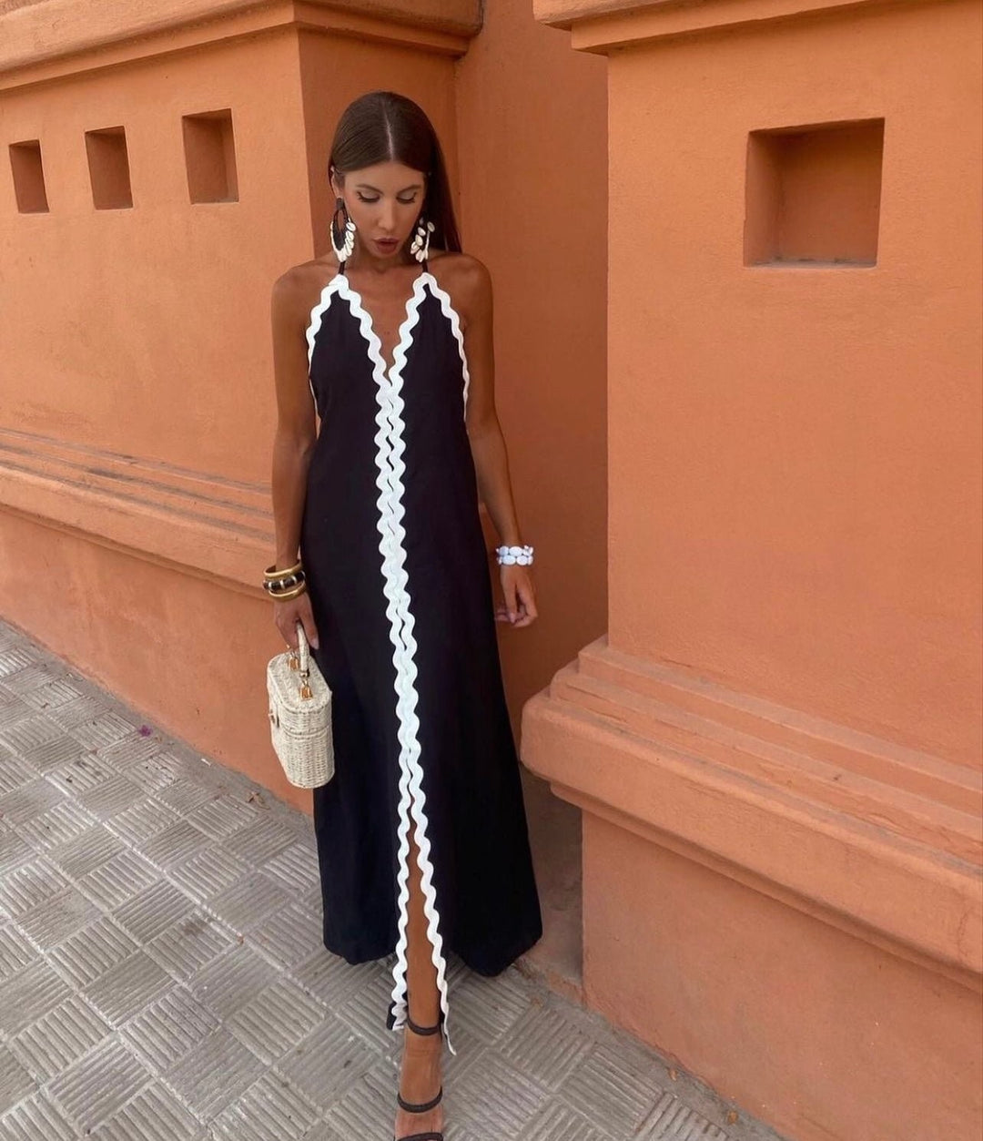 Black halterneck maxi dress with wavy white ric-rac trim and front split