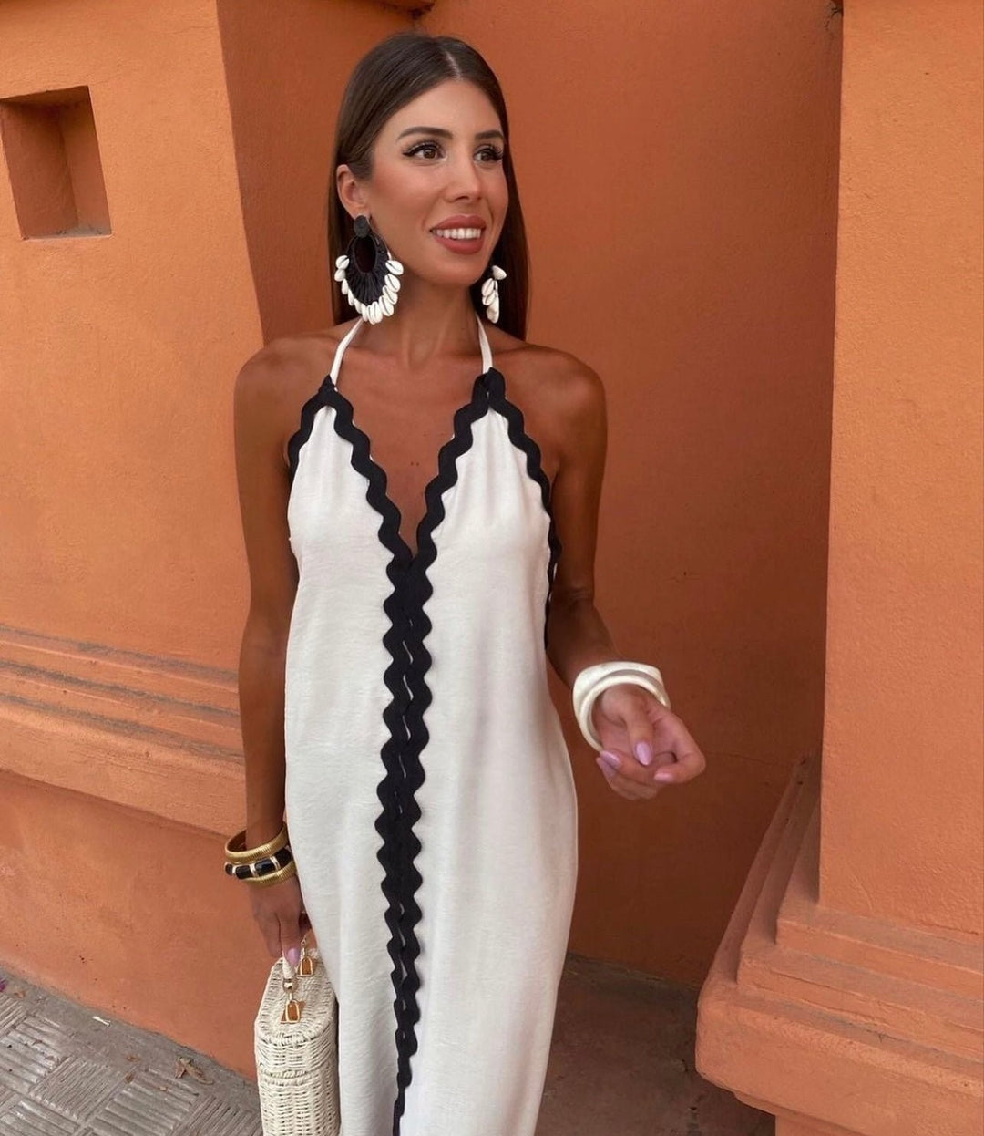 White wrap-style maxi dress with black scalloped trim and plunging neckline