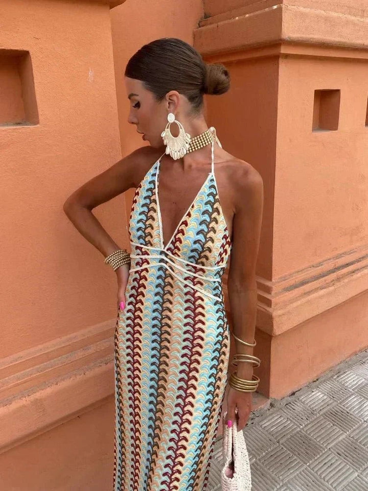 Backless crochet maxi dress showing bun hairstyle and gold cuff bracelets