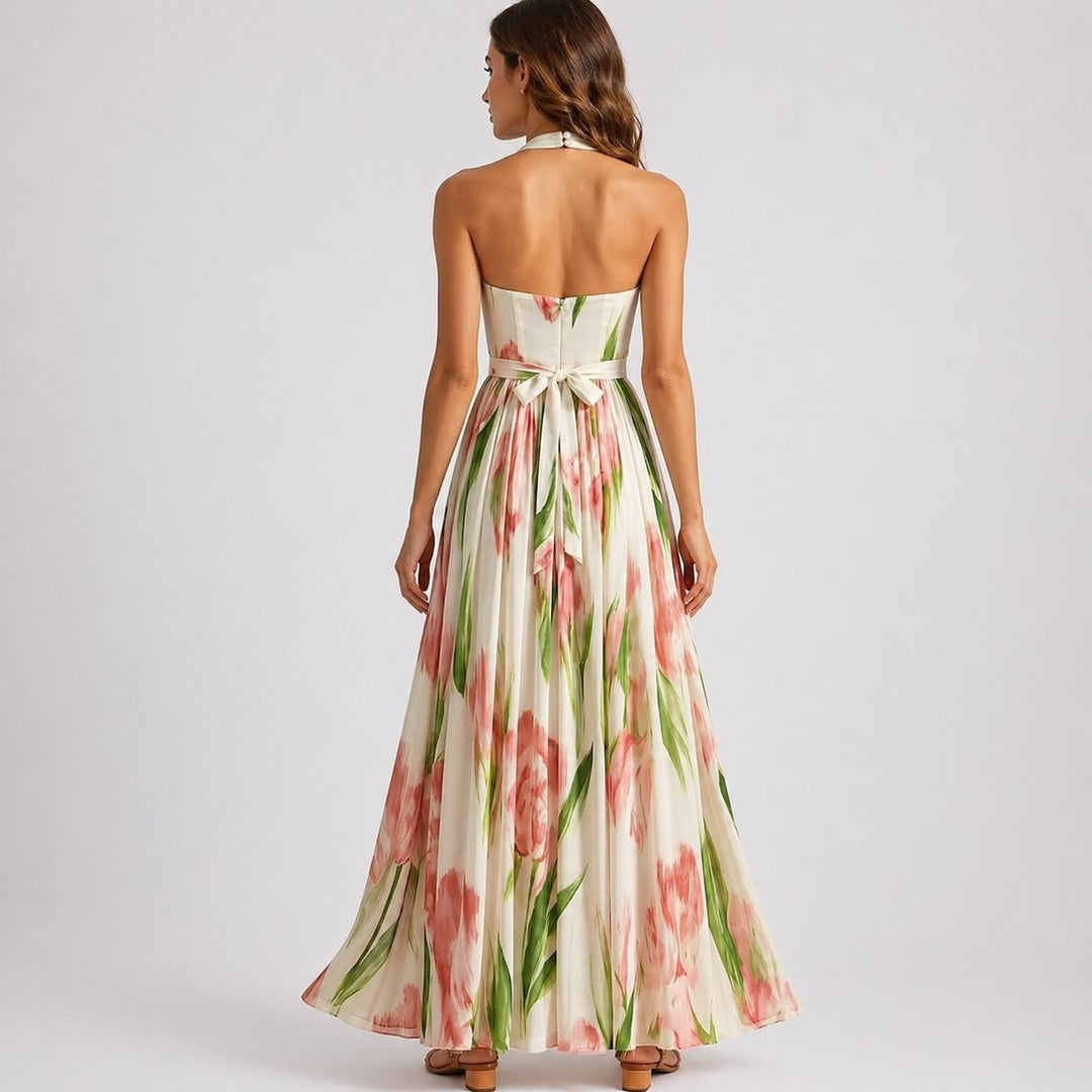 Backless halter maxi dress showing tie-waist bow and flowing floral skirt