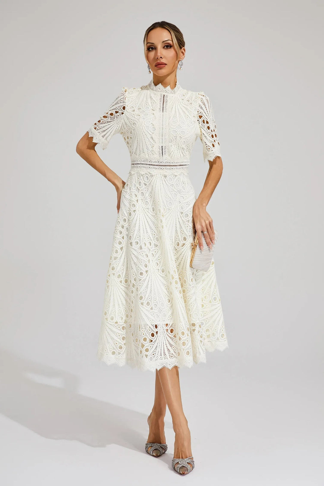 Ivory lace midi dress paired with a pleated satin clutch bag