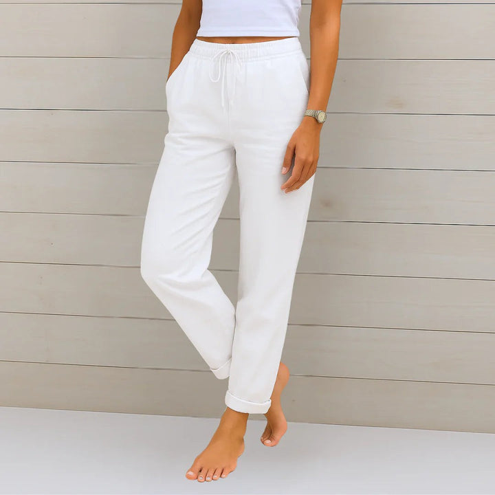 White linen-blend trousers featuring elasticated drawstring waist and rolled hems