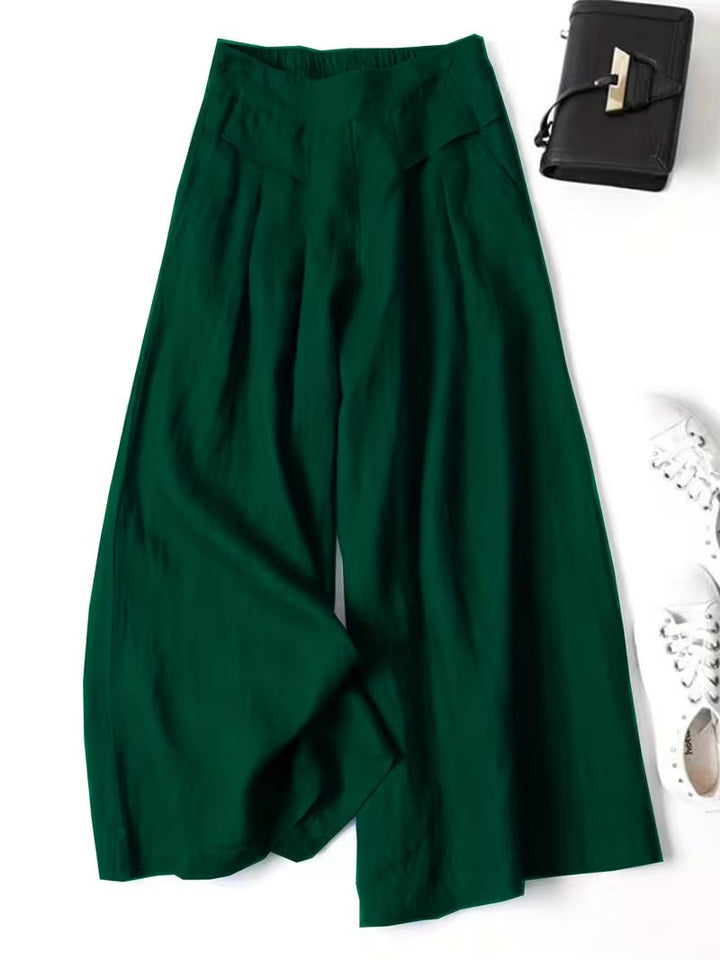 Emerald green wide-leg trousers featuring pleated front and elasticated waistband