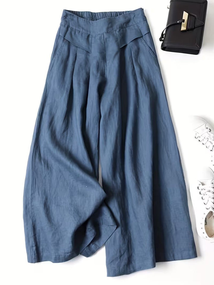 Slate blue wide-leg trousers with pleated waistband and lightweight linen fabric