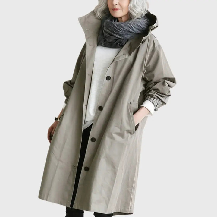 Taupe hooded longline trench coat with button placket, worn over knitwear
