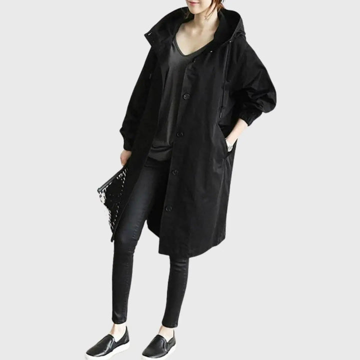 Black oversized hooded trench coat styled with skinny jeans and loafers