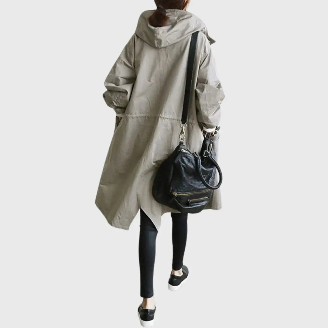Sage-grey longline hooded trench coat worn with crossbody bag, back view