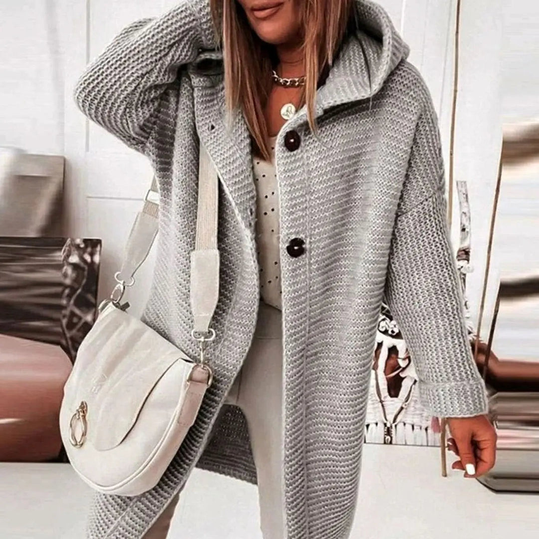 Grey hooded knit cardigan with button fastening, worn oversized with a shoulder bag