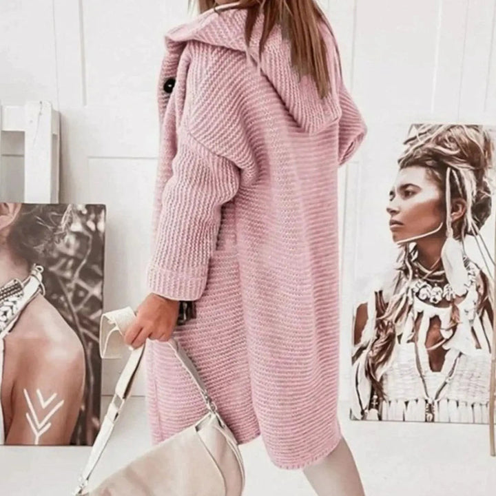 Rear view of pink knitted longline cardigan showing oversized hood and ribbed texture