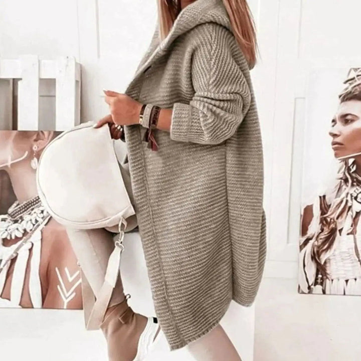Side profile of beige knit cardigan showing hooded collar and longline hem