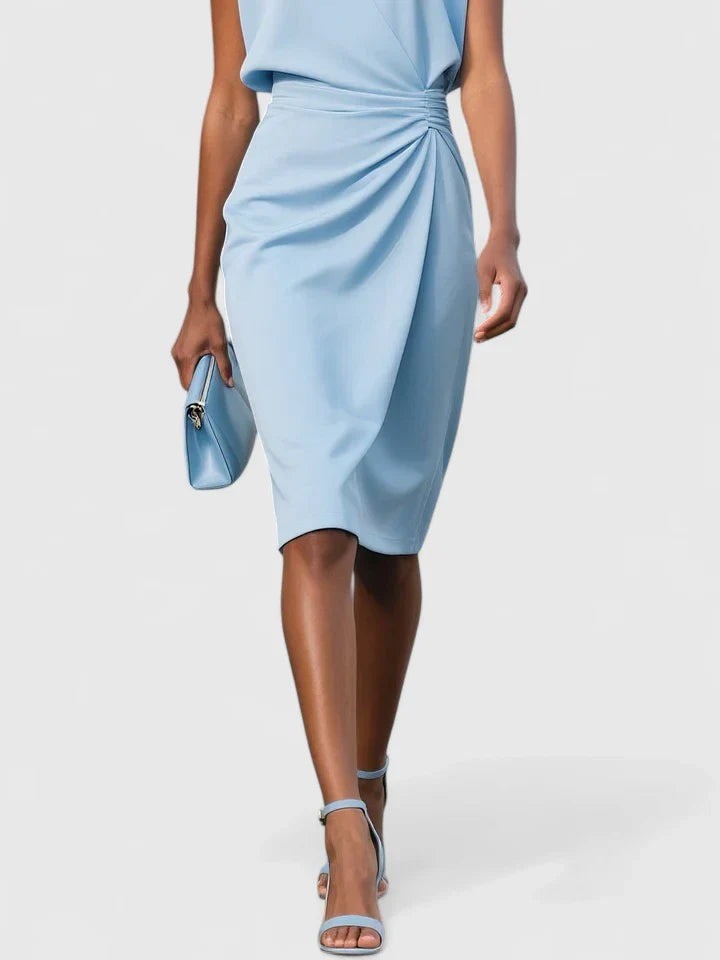 Close-up of pale blue ruched midi dress skirt with wrap-style hem