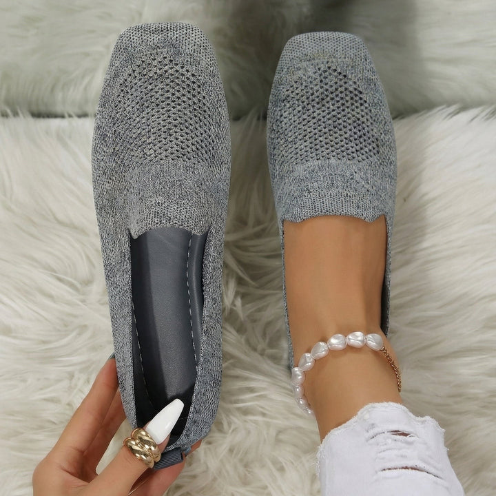 Grey knitted flat loafers with perforated toe detail and slip-on style
