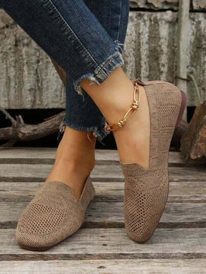 Beige knitted slip-on loafers worn with cropped denim jeans