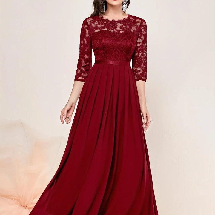 Burgundy lace maxi dress close-up highlighting floral sleeves and satin waistband