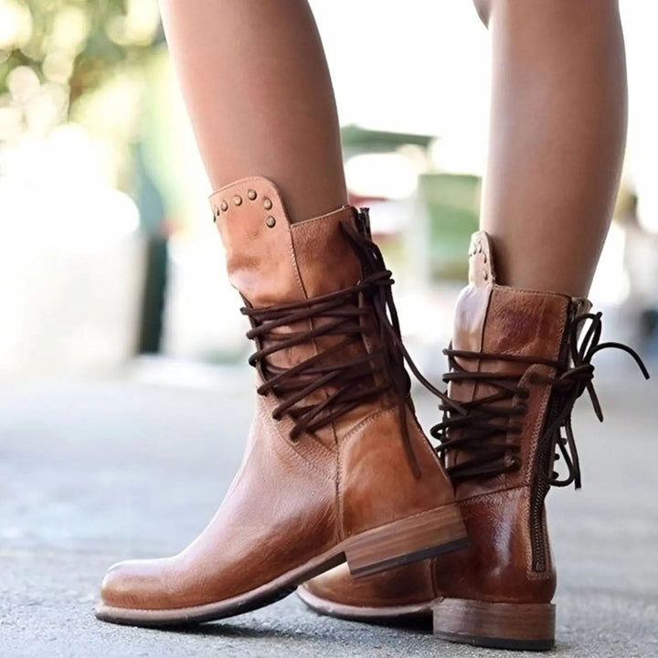 Brown leather lace-up mid-calf boots with studded panel, styled outdoors