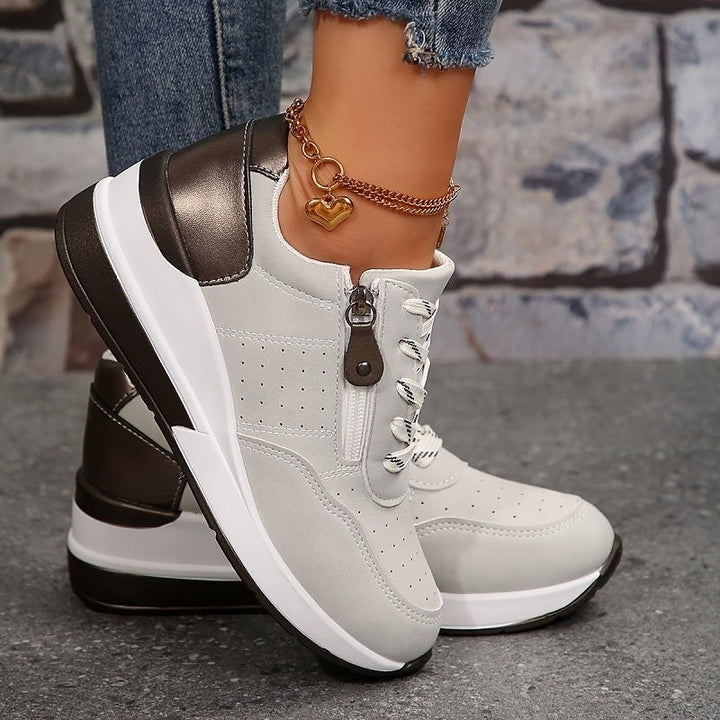 Grey lace-up trainers showing platform sole and side zip closure