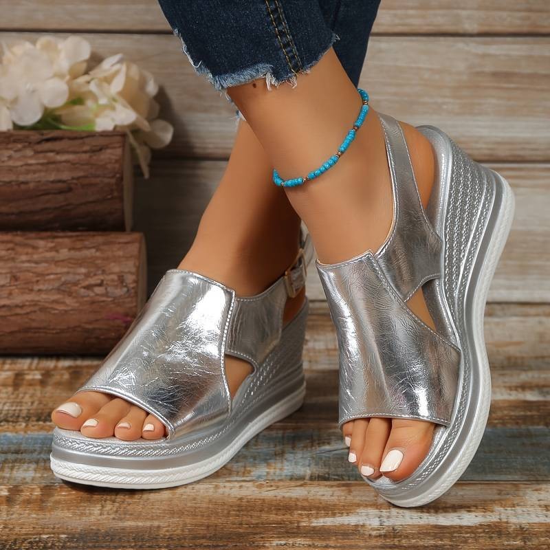 Metallic silver wedge platform sandal with ankle buckle strap and cut-out sides