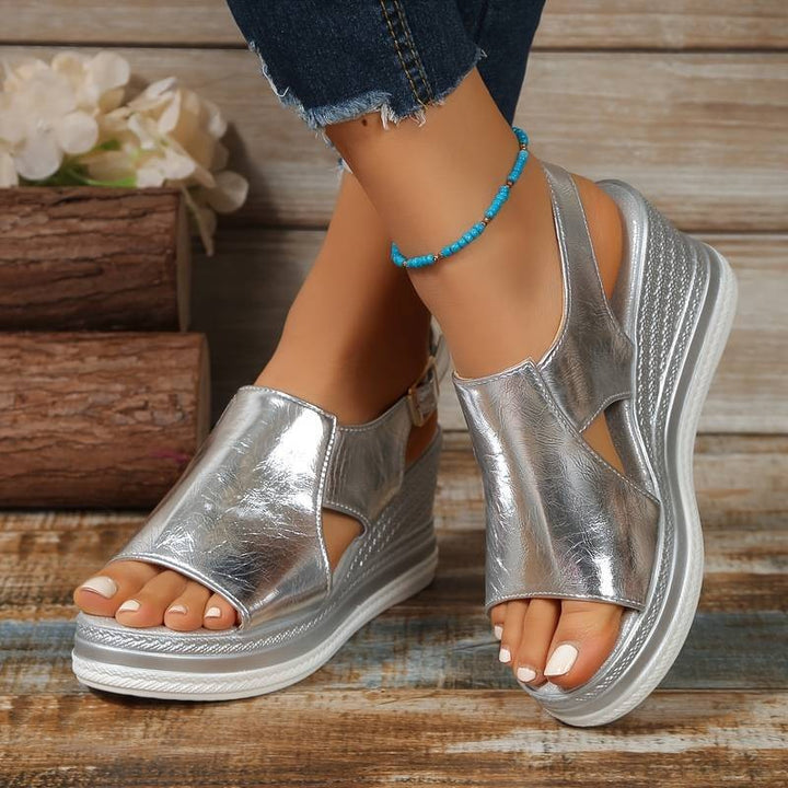 Metallic silver wedge platform sandal with ankle buckle strap and cut-out sides