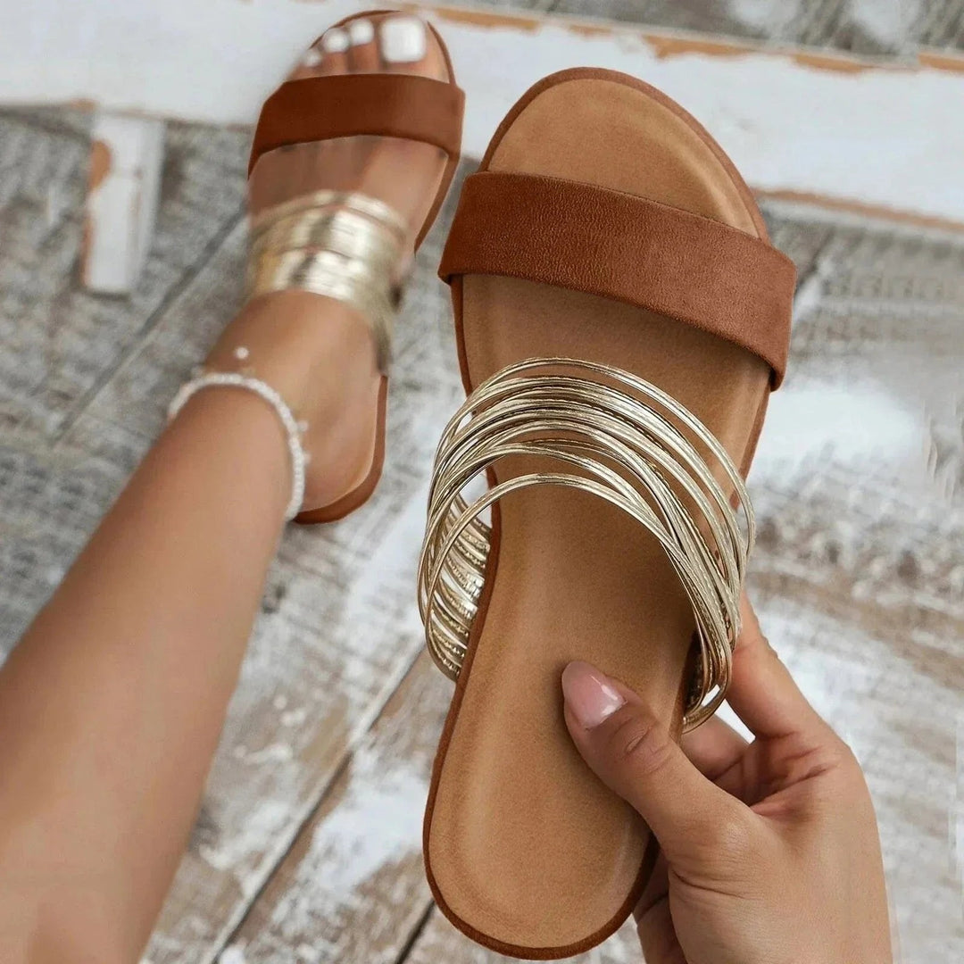 Tan suede slide sandals with strappy gold metallic accent and open toe