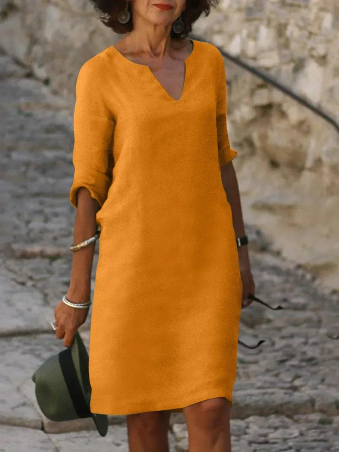 Mustard yellow notch-neck dress featuring mid-length sleeves and a shift silhouette