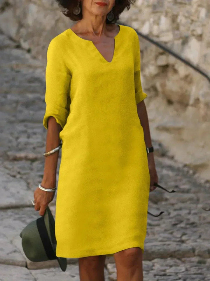 Bright yellow V-neck midi dress with mid-length sleeves and relaxed shape