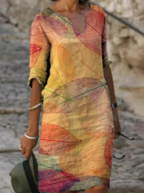 Notched V-neck midi dress in warm leaf-print pattern with long sleeves