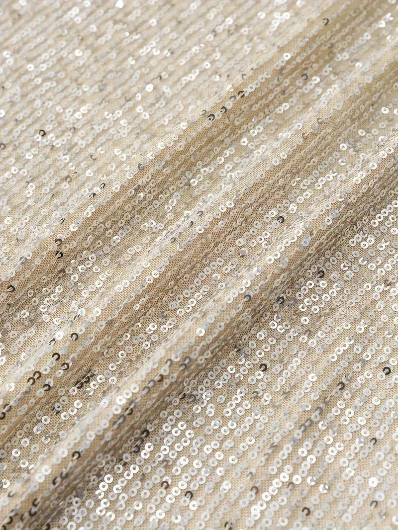 Close-up of cream sequin fabric showing ribbed sparkle texture
