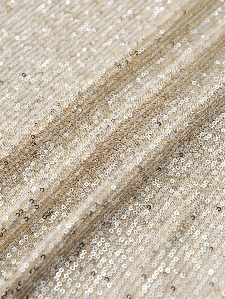 Close-up of cream sequin fabric showing ribbed sparkle texture