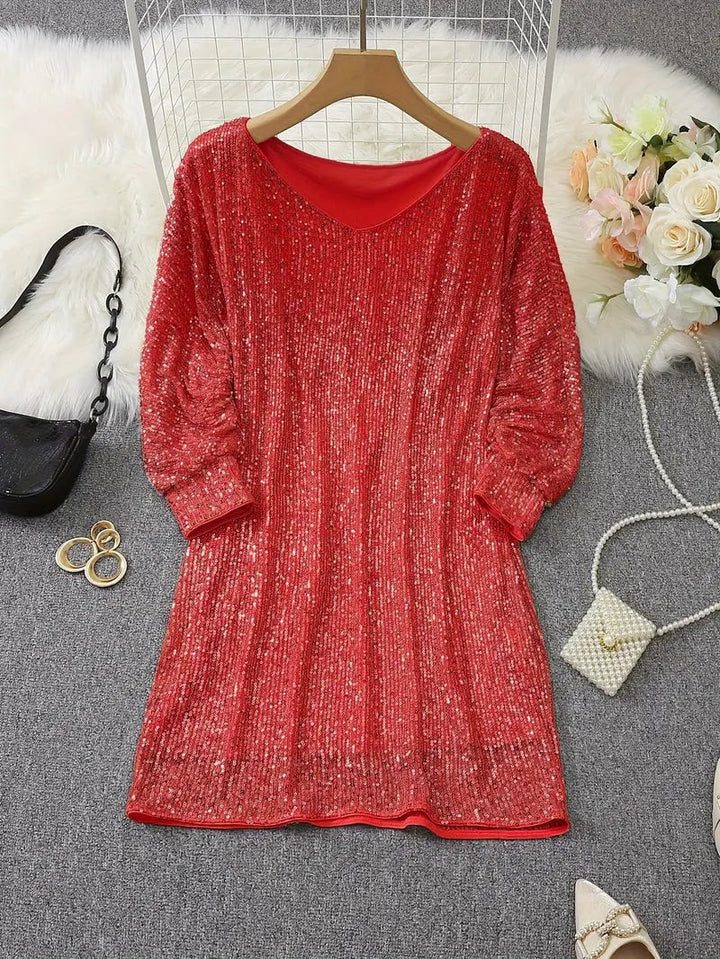 Red sequin mini dress laid flat showing round neckline and long sleeves