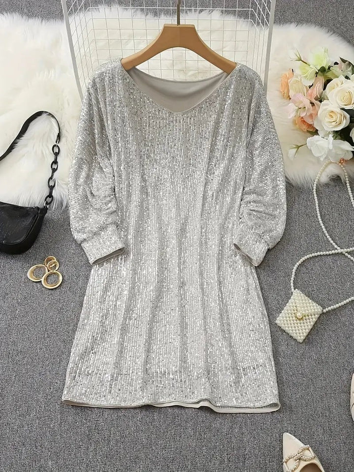 Silver sequin mini dress displayed on hanger with round neckline