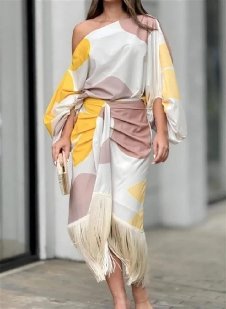 One-shoulder satin midi dress in abstract print, worn with a gold clutch