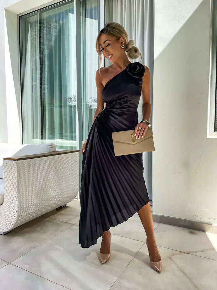 Black pleated one-shoulder dress with rosette shoulder detail and cut-out waist