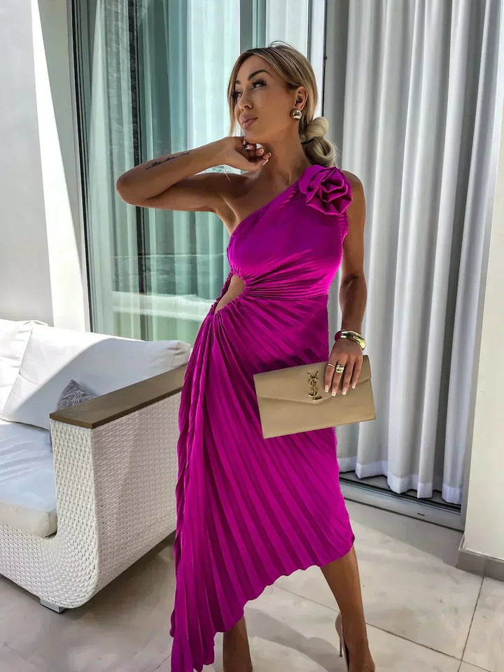 Close-up of magenta pleated dress with rose shoulder embellishment and cut-out waist