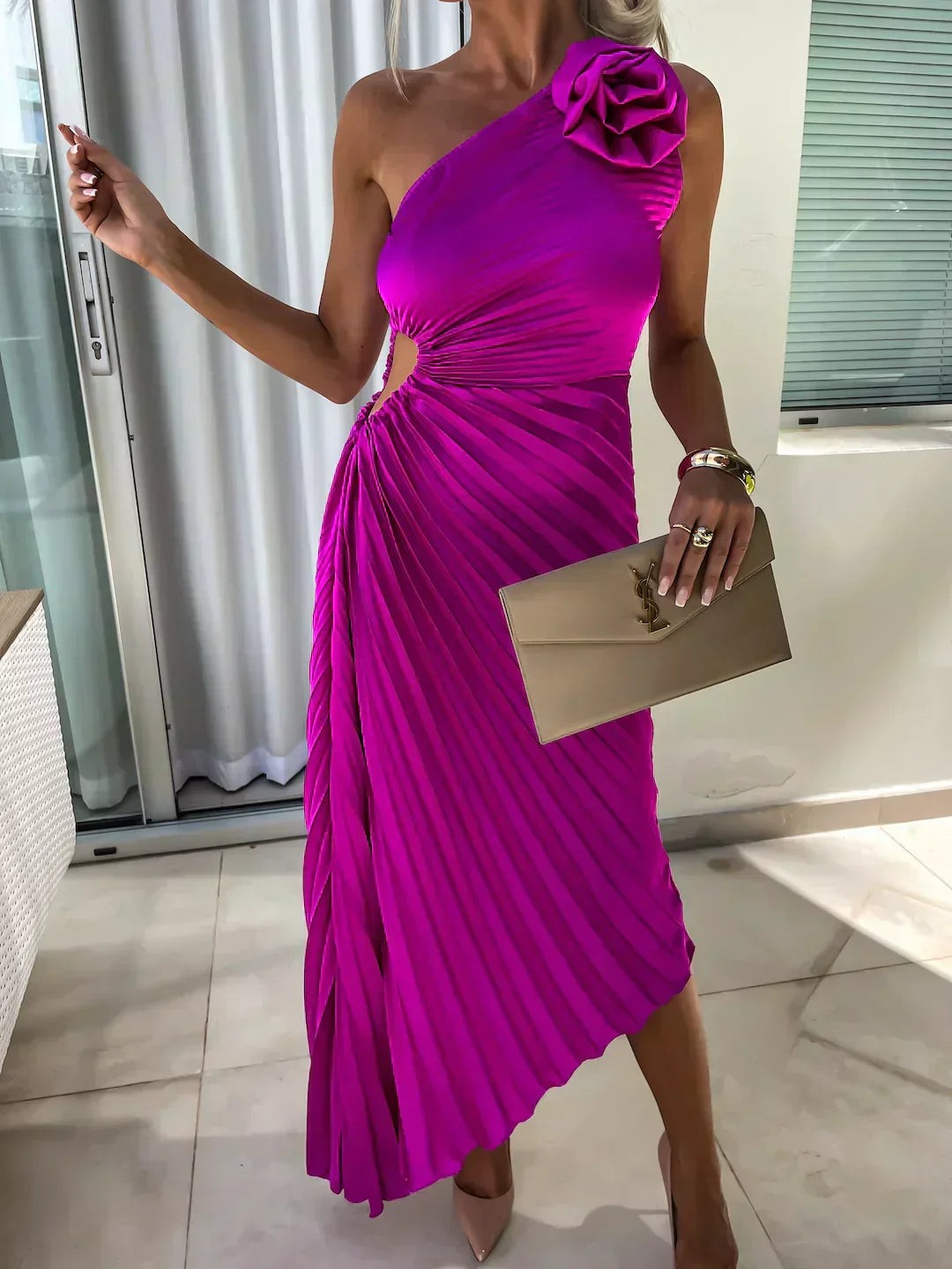 Fuchsia pleated cut-out dress worn one-shoulder with rose flower embellishment