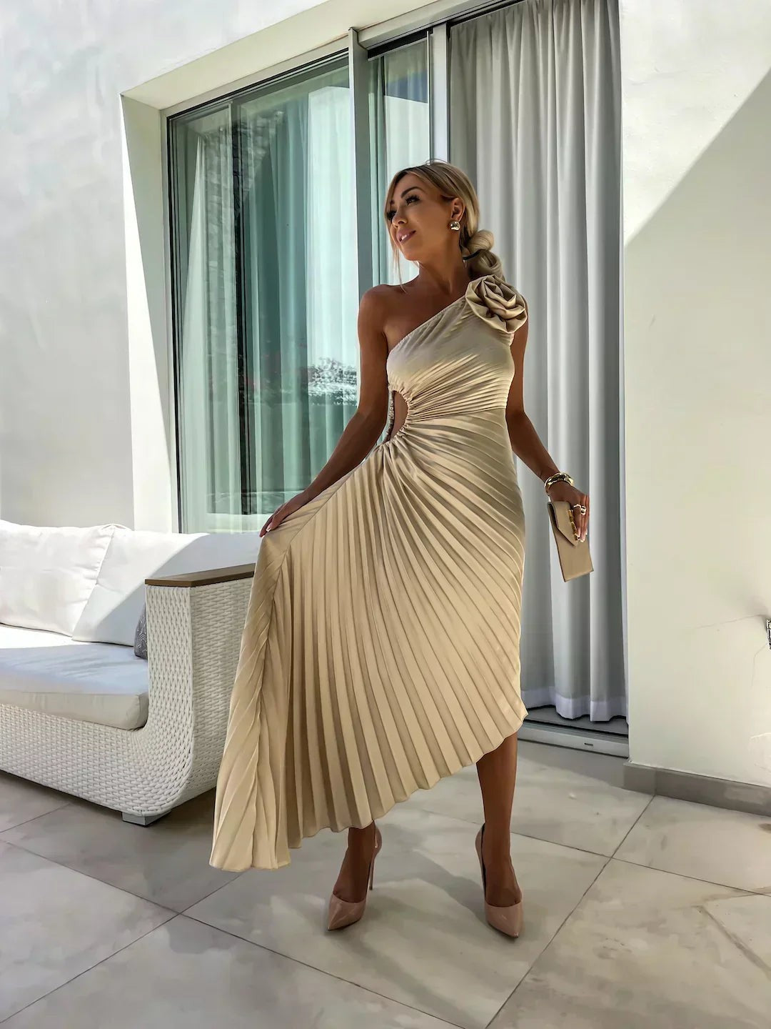 Champagne pleated one-shoulder midi dress featuring rosette detail and waist cut-out