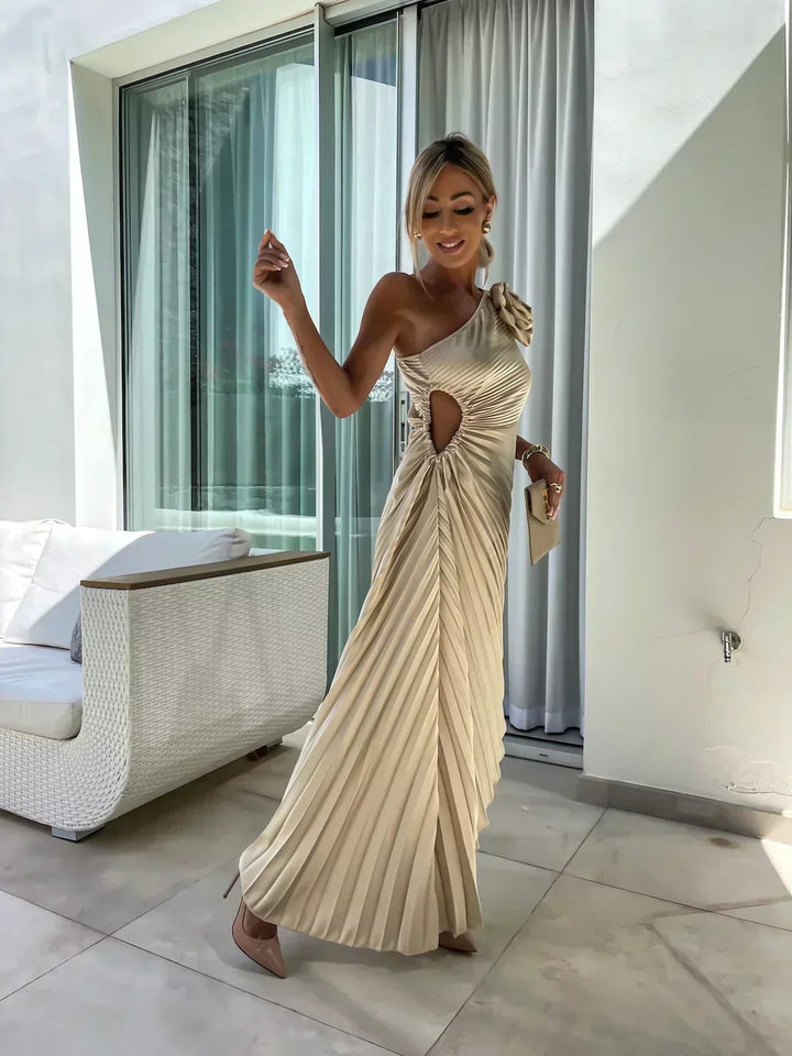 One-shoulder cream pleated maxi dress with rosette detail and asymmetric hem