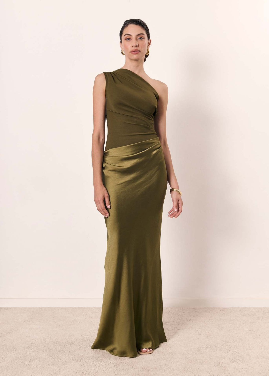Front-facing olive satin one-shoulder gown with fitted bodice and flowing skirt