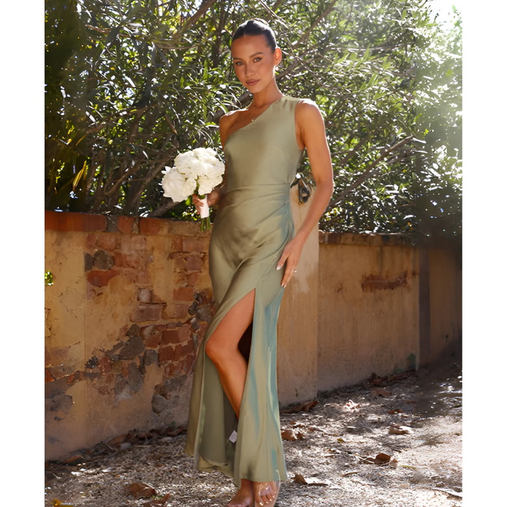 Sage green one-shoulder maxi dress styled with strappy heels and bouquet