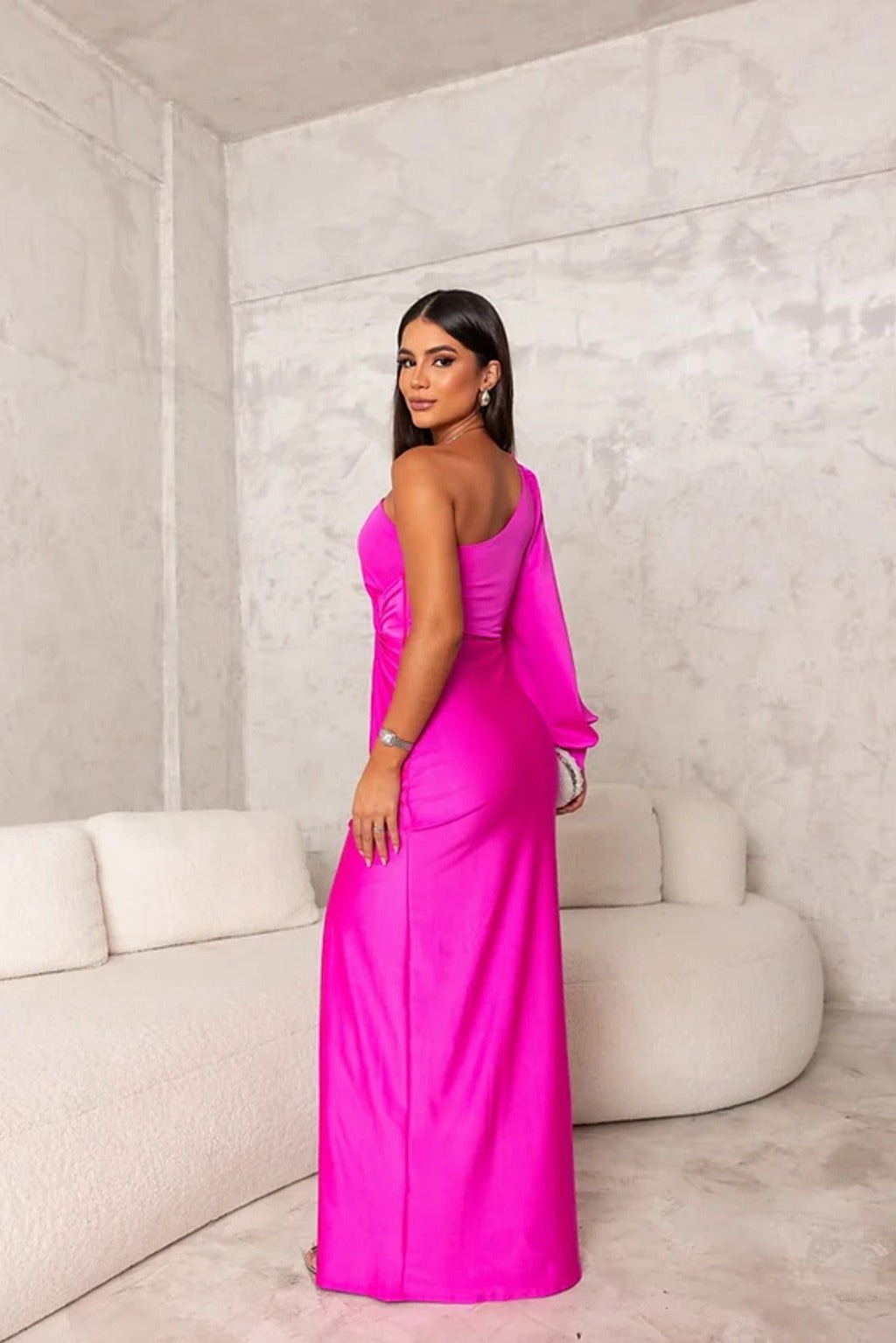 Fuchsia satin one-shoulder maxi dress viewed from behind with flowing sleeve