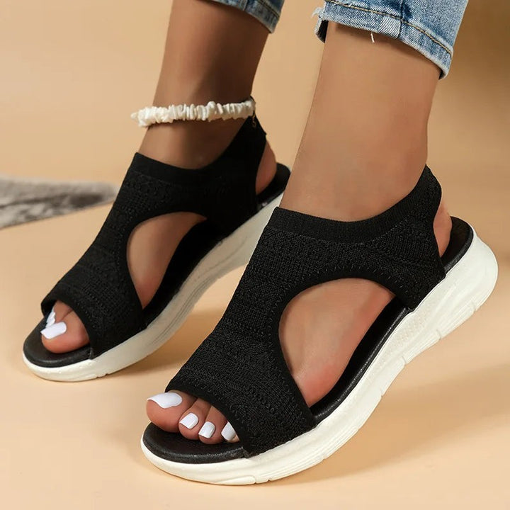 Black knitted open-toe sports sandals with cut-out sides and thick white sole